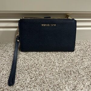 Navy Michael Kors wristlet with double zippers, cc holders and snaps close